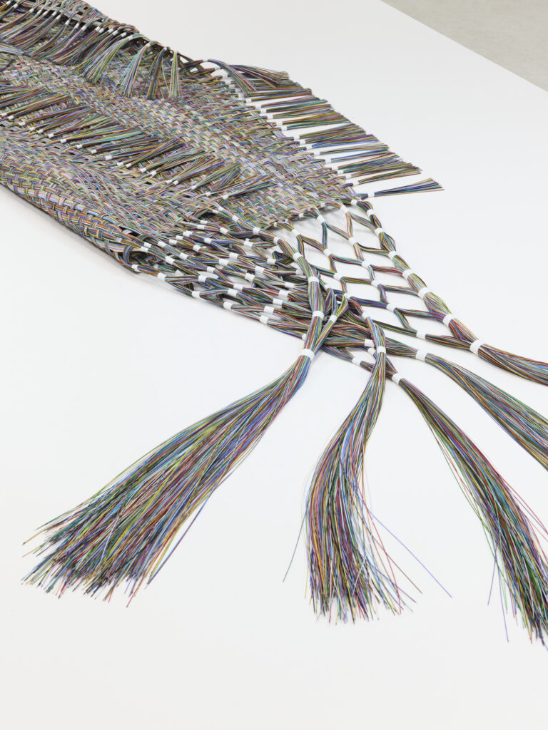 tissage de 350 cm en fibres optiques colorées, posé au sol et légèrement plié sur lui-même, vers l'intérieur.