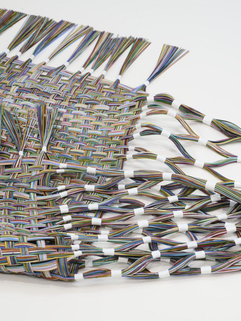 tissage de 350 cm en fibres optiques colorées, posé au sol et légèrement plié sur lui-même, vers l'intérieur.